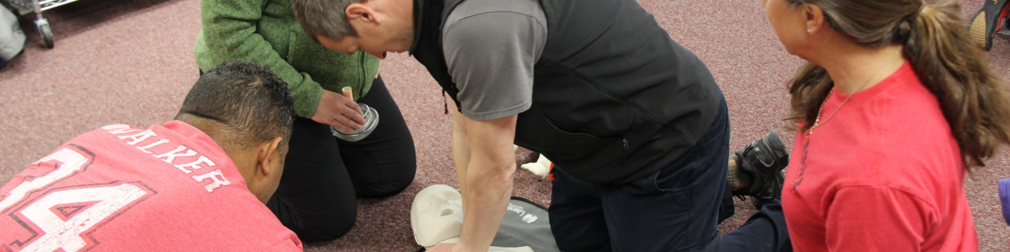 Instructor Lester Stoltz teaches a small group how to perform CPR.